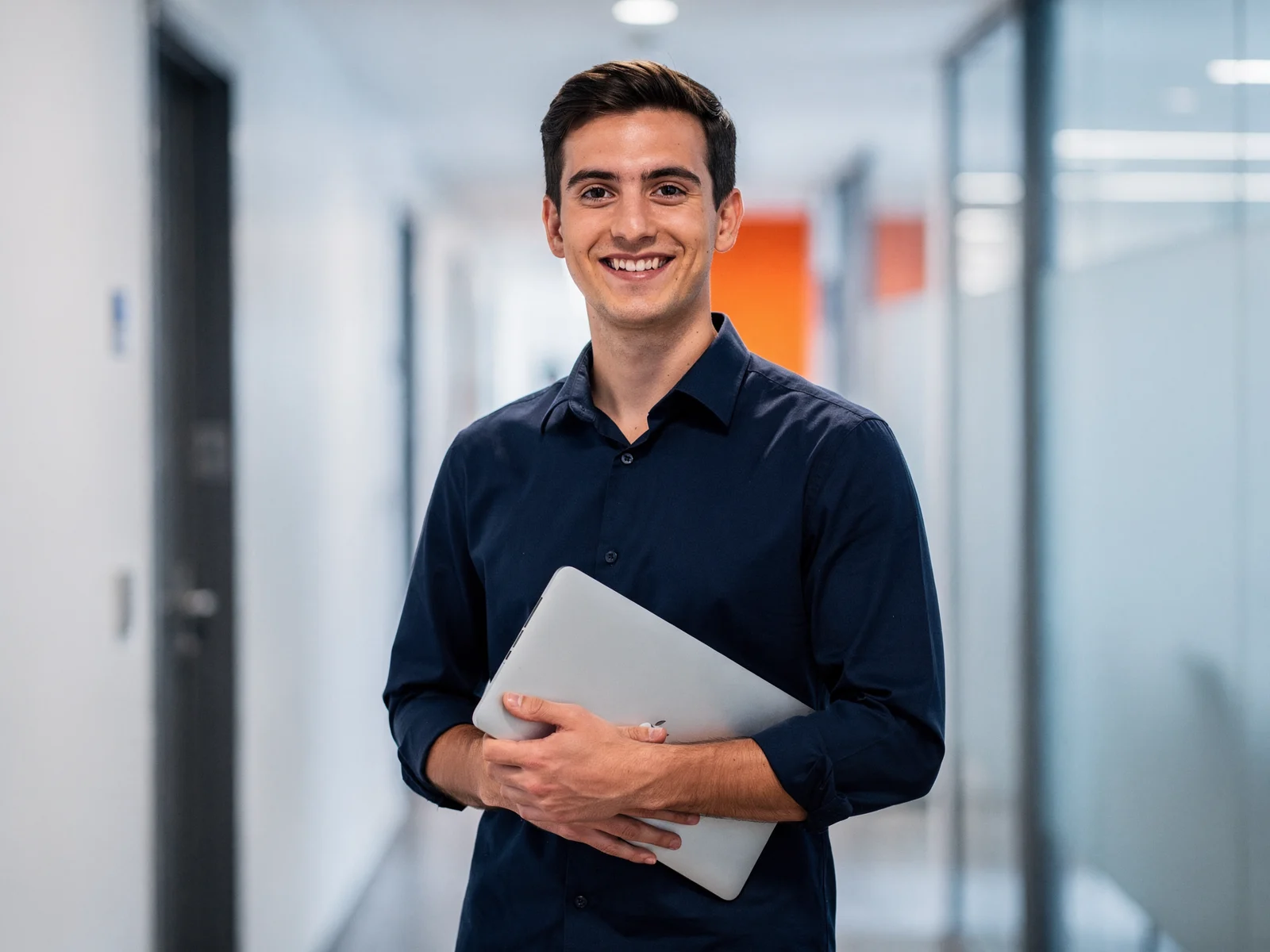Smiling software developer holding a laptop